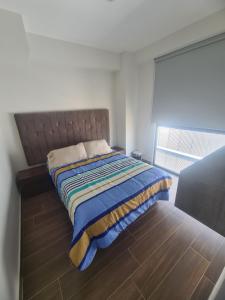 1 dormitorio con 1 cama y suelo de madera en Departamento con vista increíble en piso 16 en Guadalajara