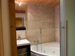 a bathroom with a bath tub and a sink at Ferienapartement Hinterdorf in Zermatt