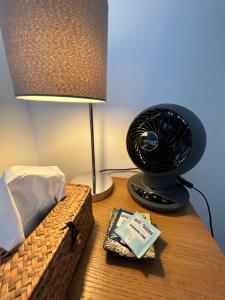 a desk with a lamp and a book and a fan at Beautiful Double Room for One Person in Hither Green