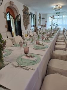 a long table with white tables and white chairs at Hotel Lo Smeraldo in Roccavivara