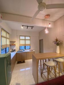 uma cozinha e sala de jantar com mesa e cadeiras em Cozy Apartment - Sri Lagenda Resort Langkawi em Kuah