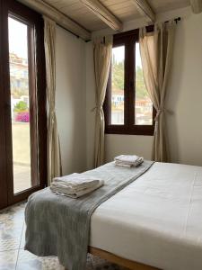 ein Schlafzimmer mit einem Bett mit zwei Handtüchern darauf in der Unterkunft Poros endless view apartment in Poros