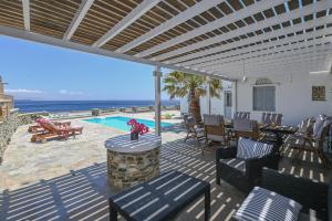 a patio with a table and chairs and a pool at Santamare Villa in Tinos Town