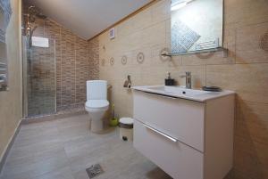 ein Badezimmer mit einem weißen Waschbecken und einem WC in der Unterkunft Portile Ocnei in Târgu Ocna