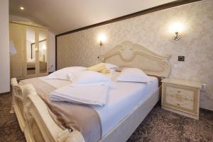 トゥルグ・オクナにあるPortile Ocneiのベッドルーム1室(大型ベッド1台、白いシーツ、枕付)