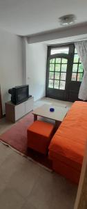Habitación con cama, mesa y TV. en Apartman NeSa Boracko jezero, en Konjic