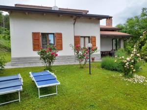 uma casa com duas cadeiras azuis no quintal em Via del Fusato 13 Casa Carla em Chiusi della Verna