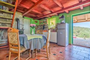 eine Küche mit einem Tisch und einem Kühlschrank in der Unterkunft STONE HOUSE ANA in Škrip