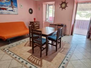 ein Esszimmer mit einem Tisch, Stühlen und einem Sofa in der Unterkunft Maridea - Fragolino in Ponza