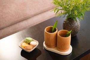 une table avec deux tasses et une plante en pot dans l'établissement Tuong Boutique Resort Mui ne, à Mui Ne