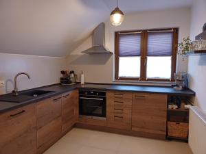 a kitchen with wooden cabinets and a sink and a window at Mountain Dream in Korenica