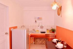 a kitchen with a white refrigerator and a table at Tiny yet Beautiful apartment in the heart of Phnom Penh, Near central market in Phnom Penh