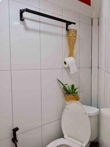 a bathroom with a toilet and a plant on the wall at Tiny yet Beautiful apartment in the heart of Phnom Penh, Near central market in Phnom Penh