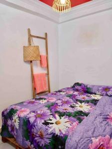 a bedroom with a purple bed with flowers on it at Tiny yet Beautiful apartment in the heart of Phnom Penh, Near central market in Phnom Penh