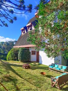 une maison avec un banc dans la cour dans l'établissement Casa Suiça de Campos, à Campos do Jordão