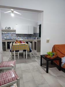 a living room with a table and a kitchen at Villa Lucia in Santa Maria Del Focallo