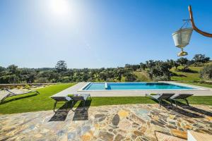 a swimming pool with two chairs and a table at Casa do Avô (Vale Luís Neto-Retiro do Caldeirão) in Loulé