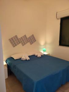 a bedroom with a blue bed with two towels on it at Villa Lucia in Santa Maria Del Focallo