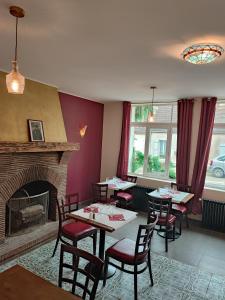 una sala da pranzo con tavoli, sedie e camino di la madeleine a Saint-Benoît-sur-Loire