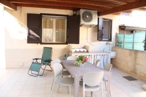a patio with a table and chairs and a kitchen at Casa Bonsai in Cava dʼAliga