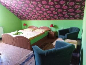 1 dormitorio con 1 cama y 2 sillas en Ubytovanie Penzión Iveta en Poltár