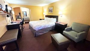 um quarto de hotel com uma cama e uma cadeira em Apollo Lodge and RV Park em Fairfield