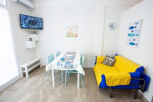 馬里納－迪拉古薩的住宿－Casa Elda，一间带桌子和黄色沙发的用餐室