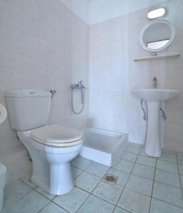 a white bathroom with a toilet and a sink at Studio's Stelios in Leptokaria