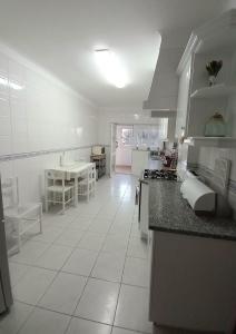 cocina con suelo de baldosa blanca y encimera en Apartamento Amarelinha, en Lagos