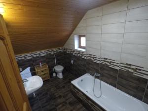uma casa de banho com um lavatório, uma banheira e um WC. em Napsütötte Kehida em Kehidakustány