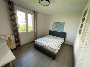 ein Schlafzimmer mit einem Bett in einem Zimmer mit einem Fenster in der Unterkunft Maison de ville,RER A 20 min pour Paris/Disneyland in Neuilly-sur-Marne