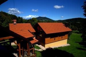 two buildings with red roofs on a green field at Brezova Poljana Lodge in Vrbovsko