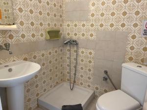 a small bathroom with a toilet and a sink at Villa Maria Petru in Ierissos