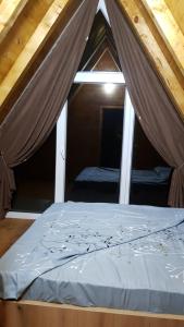 uma cama num quarto com uma janela em Dawn Villas em Ferizaj