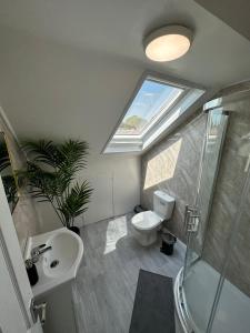La salle de bains est pourvue de toilettes, d'un lavabo et d'une lucarne. dans l'établissement DVM escape Flat 3, à Bristol