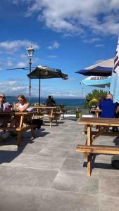 a group of people sitting at picnic tables with umbrellas at Magnificent Views over Dungarvan Bay, Ring, Waterford , Panoramic Sea Views, in Dungarvan