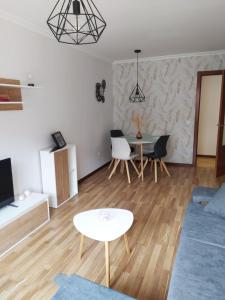 ein Wohnzimmer mit einem blauen Sofa und einem Tisch in der Unterkunft COQUETO APARTAMENTO EN OVIEDO in Oviedo