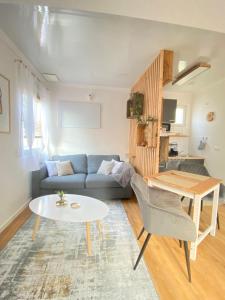 a living room with a blue couch and a table at Tiny-Haus Straußenblick 1 in Bad Fallingbostel