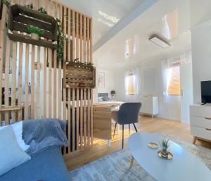 ein Wohnzimmer mit einem blauen Sofa und einem Tisch in der Unterkunft Tiny-Haus Straußenblick 1 in Bad Fallingbostel