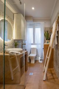 een badkamer met een wastafel, een toilet en een spiegel bij Paxos Fairytales House 1 in Gaios