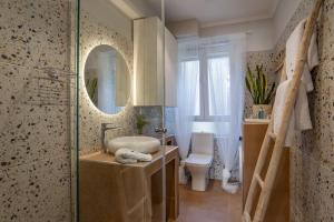 een badkamer met een wastafel, een spiegel en een toilet bij Paxos Fairytales House 1 in Gaios