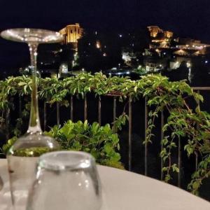 una copa de vino en una mesa con vistas a la ciudad en La Locanda del Fiume, en Pisciotta