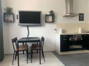 a kitchen with a table and a tv on the wall at Nad rzeką in Piła