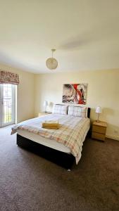een slaapkamer met een groot bed en 2 lampen bij 26 Woodgrove Drive in Inverness