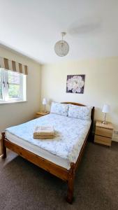 een slaapkamer met een bed met 2 nachtkastjes en 2 lampen bij 26 Woodgrove Drive in Inverness