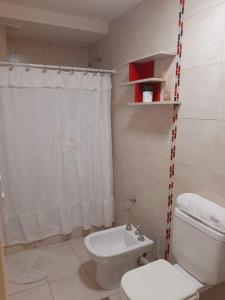 y baño con aseo blanco y ducha. en Hermoso departamento céntrico! en San Miguel de Tucumán