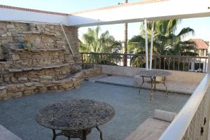 eine Terrasse mit zwei Tischen und einer Steinmauer in der Unterkunft Nuve Express Abasolo in Torreón + 15 Fotos