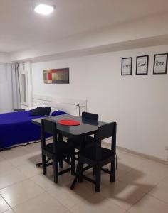 um quarto com uma mesa e cadeiras e uma cama em Hermoso departamento céntrico! em San Miguel de Tucumán