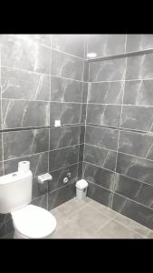 a bathroom with a toilet and a tiled wall at I can host in Bursa