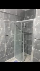 a shower with a glass door in a wall at I can host in Bursa